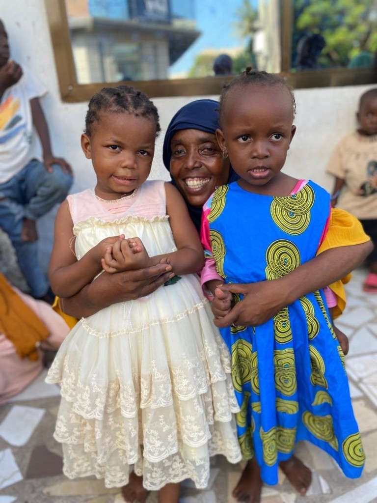 Volunteer embracing children during a GHOTA community outreach visit